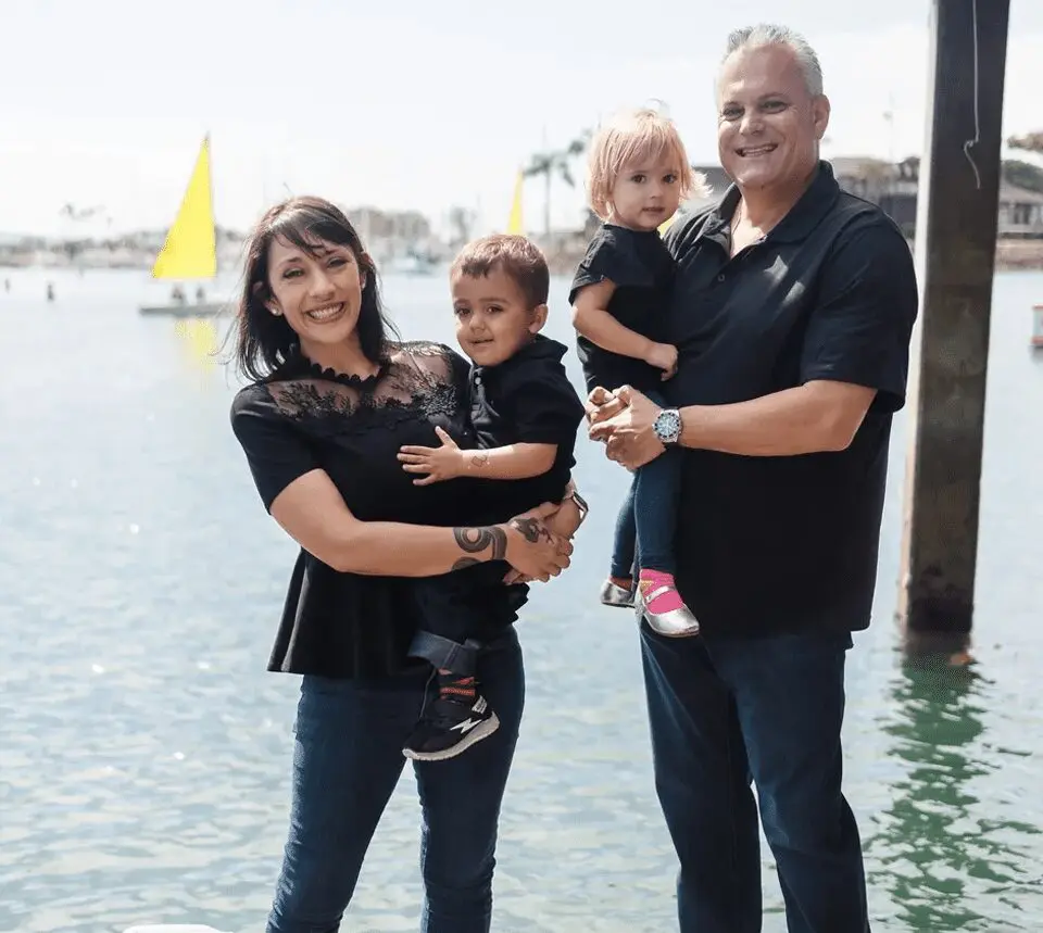 A family posing for a picture in front of the water.