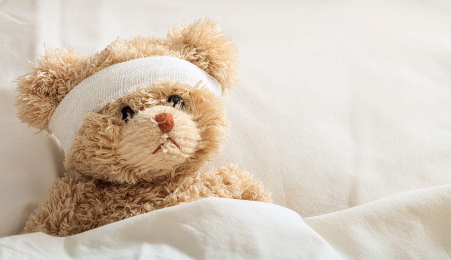 A teddy bear with bandages on its head.