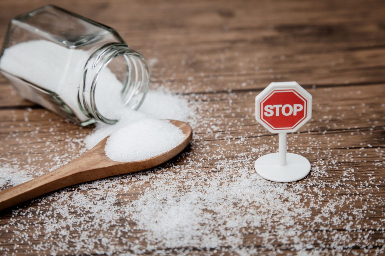 A stop sign and spoon with salt on the floor