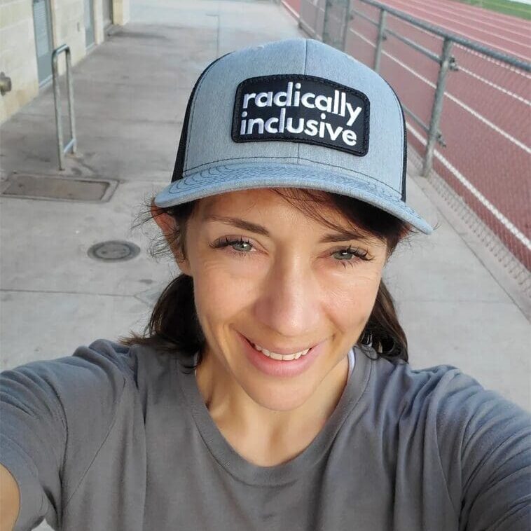 A woman wearing a hat and smiling for the camera.